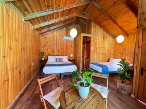 two beds in a room with wooden walls at Barros Wellness & Spa Resort Boutique in Calle Larga