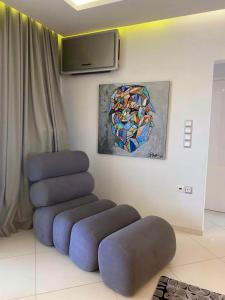 Helen Luxury Loft Design MEISONETTE-APARTMENT في أثينا: اثنين من الكراسي الزرقاء في غرفة مع لوحة