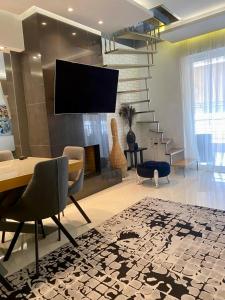 Helen Luxury Loft Design MEISONETTE-APARTMENT في أثينا: غرفة معيشة مع طاولة وتلفزيون على الحائط