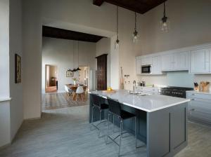 een keuken met witte kasten en een groot eiland bij Villa Perpenti in Pianello Del Lario