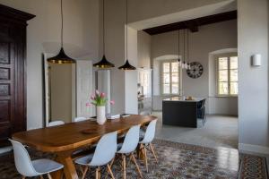 een eetkamer met een houten tafel en witte stoelen bij Villa Perpenti in Pianello Del Lario