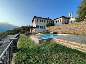 een huis met een zwembad naast een muur bij Villa Perpenti in Pianello Del Lario