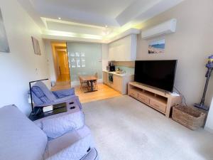 a living room with a couch and a flat screen tv at Melbourne City Central Apartment - 296 in Melbourne