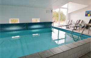 ヒアツハルスにあるBeautiful Home In Hirtshals With Sauna, Wifi And Indoor Swimming Poolの建物内の椅子付きスイミングプール