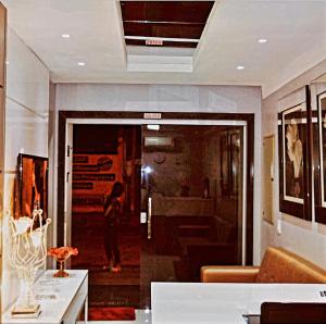a lobby with a person walking into a room at Hotel Center in Feira de Santana