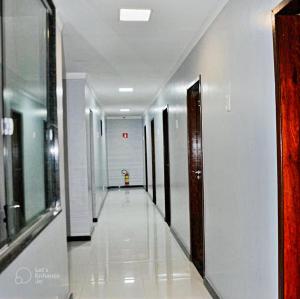 un corridoio di un edificio con pareti e porte bianche di Hotel Center a Feira de Santana