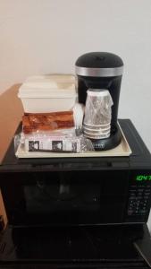 uma máquina de café sentada em cima de um micro-ondas em OSU 2 Queen Beds Hotel Room 221 Wi-Fi Hot Tub Booking em Stillwater