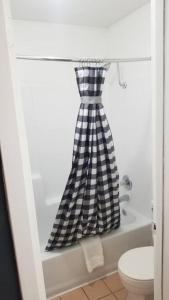 uma cortina de chuveiro em preto e branco xadrez na casa de banho em OSU 2 Queen Beds Hotel Room 221 Wi-Fi Hot Tub Booking em Stillwater