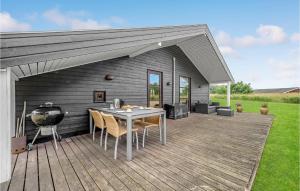 a patio with a grill and a table on a deck at 3 Bedroom Awesome Home In Ejstrupholm in Ejstrup