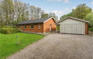 ein Backsteinhaus mit einer Garage und einer Auffahrt in der Unterkunft Pet Friendly Home In Nrre Alslev With Wifi in Nørre Alslev