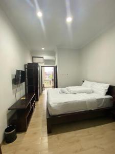 1 dormitorio con 1 cama y TV en Bethara Hotel Syariah Lampung en Tanjungkarang