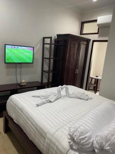 1 dormitorio con 1 cama y TV de pantalla plana en Bethara Hotel Syariah Lampung en Tanjungkarang