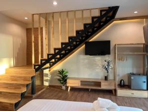 ein Wohnzimmer mit einer Treppe und einem TV in der Unterkunft Siam Beach Resort in Ko Chang