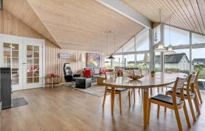 a dining room and living room with a table and chairs at Holiday Home Skræddermarken in Sønderho
