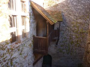 uma varanda de madeira ao lado de um edifício de tijolos em Commanderie des Templiers em Figeac