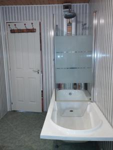 ein Badezimmer mit einem weißen Waschbecken und einer weißen Tür in der Unterkunft Punct Gastronomic Local Acasa la Vero in Schiuleşti