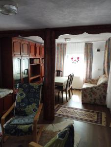 ein Wohnzimmer mit einem Tisch, Stühlen und einem Fenster in der Unterkunft Punct Gastronomic Local Acasa la Vero in Schiuleşti