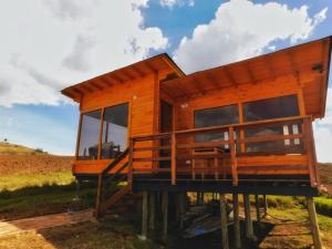 une maison sur pilotis avec une grande terrasse dans l'établissement Cabaña con vista a la laguna de Tota, à Tota