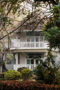 ein weißes Haus mit einer weißen Veranda und einem Balkon in der Unterkunft The Vintage Hotel KhaoYai in Nong Nam Daeng