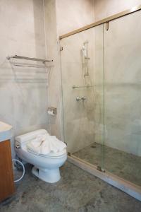 a bathroom with a toilet and a glass shower at The Vintage Hotel KhaoYai in Nong Nam Daeng