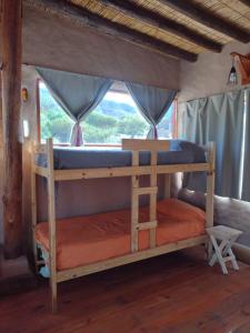 Etagenbett in einem Zimmer mit Fenster in der Unterkunft Cabaña Misk'i Nuna, en las afueras de Tilcara in Tilcara