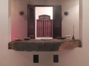 a room with a wall with a window and a table at Amanda Beach Villas in Unawatuna