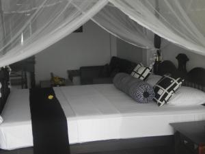 a bed with pillows on it in a room at Amanda Beach Villas in Unawatuna