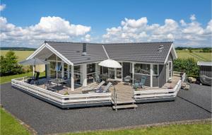 een huis met een groot terras met stoelen en parasols bij Awesome Home In Sydals With Wifi in Sønderby