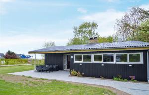 una pequeña casa negra con patio en Amazing Home In Kge With Kitchen, en Strøby Egede