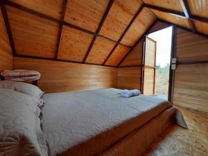 a bedroom with a bed in a wooden room at VILLA ISABELLA in Curití