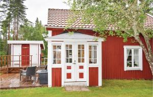 un piccolo capanno rosso e bianco con terrazza di 2 Bedroom Nice Home In Nssj a Nässjö