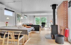 a living room with a table and a fireplace at Stunning Home In Assens With Kitchen in Assens