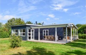 a blue tiny house with a large deck at 3 Bedroom Nice Home In Tranekr in Lohals