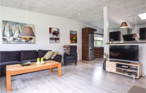 sala de estar con sofá y TV en 3 Bedroom Nice Home In Tranekr, en Lohals