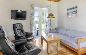 a living room with a couch and chairs and a tv at Cozy Apartment In Allinge With Wifi in Allinge