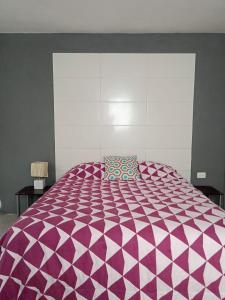 a large purple and white bed in a room at TR3S by Walter de la Renta in Cancún