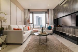 ein Wohnzimmer mit einem Sofa und einem TV in der Unterkunft 8 Kia Peng Residences by Times 8 in Kuala Lumpur