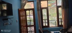 Zimmer mit Türen und Fenstern in einem Zimmer in der Unterkunft Mountain and Moon, Dharamkot in Dharamshala
