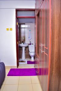 a bathroom with a toilet and a sink at Rozy Penthouse in Kisumu