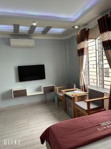 Zimmer mit einem Bett und einem TV an der Wand in der Unterkunft Cat Ba Central Homestay in Cát Bà