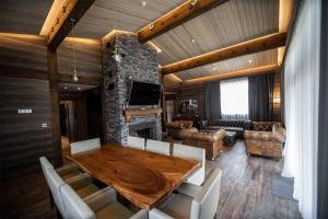 a living room with a wooden table and a fireplace at Le Chalet by Amirsoy in Chimgan