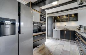 a kitchen with stainless steel appliances and a tile floor at Beautiful Home In Harboøre With Sauna in Harboør +23 photos