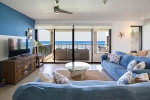 a living room with a blue couch and a view of the ocean at Beachfront Luxury with Incredible Ocean Views apts in Christ Church