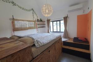 1 dormitorio con cama, ventana y lámpara de araña en Bali Villa Pokhara en Pokhara