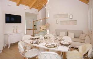 a dining room with a white table and chairs at Beautiful Home In Seget Donji With Heated Swimming Pool in Trogir