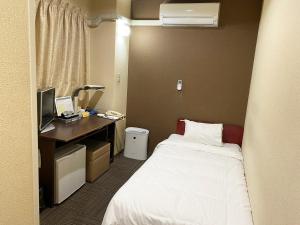 a hotel room with a bed and a desk with a computer at ビジネスホテル ごとう＠ＮＥＴ in Kure