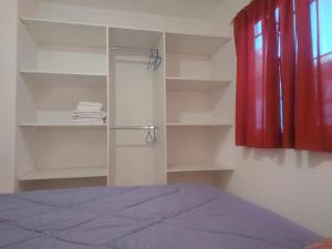 a bedroom with a bed and shelves and a red curtain at Los Olivos Apart in San Rafael +29 photos