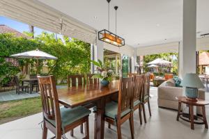een eetkamer met een houten tafel en stoelen bij Villa Luxe - Ultra Luxury 4 Bedroom in Koh Samui 