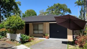 une maison avec un parasol devant elle dans l'établissement Home Away From Home-(Room1&2), à Gold Coast