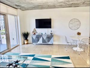 a living room with a table and a tv at Platinum 2BD 2BTH at Midblock in Miami